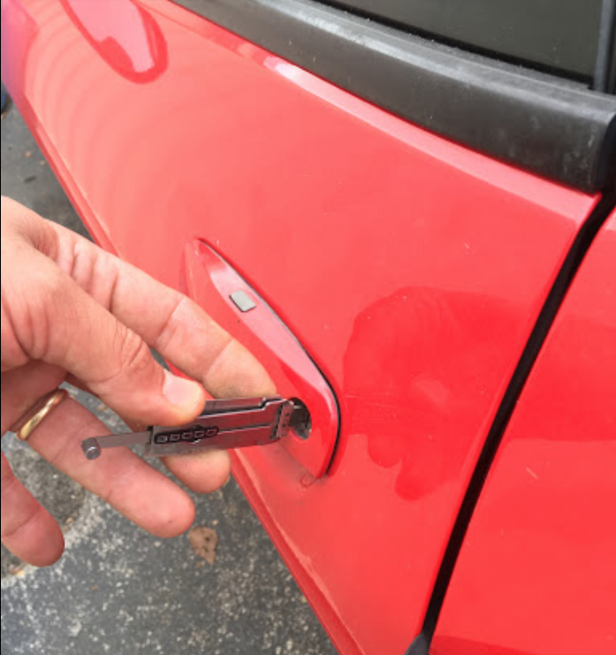 locksmith using a Lishi tool to unlock a car door lock
